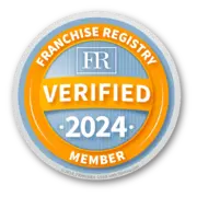 Circular badge displaying "FR" at the top, with "Franchise Registry Verified 2024 Member" in prominent text. The badge has an orange border and a blue background.